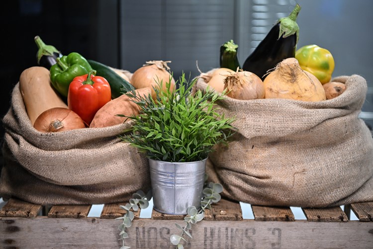 Sacks of vegetables and a pot of herbs